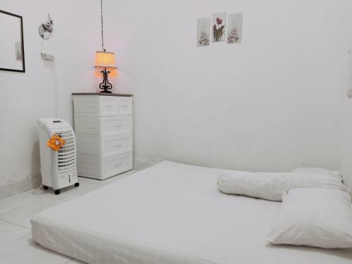 Waha的住宿－Wambuliga Homestay，一间白色卧室,配有两张床和散热器