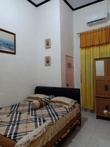 Waha的住宿－Wambuliga Homestay，一间卧室配有床和黄色窗帘