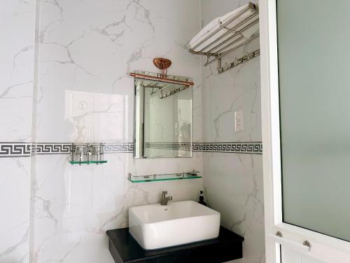 Baño blanco con lavabo y espejo en Cao Lanh Hotel, en Ấp Mỹ Ðông
