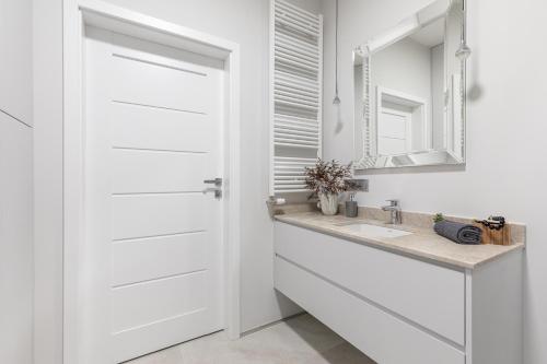 een badkamer met een witte deur en een wastafel bij SuperApart Stanisława Augusta 42 in Warschau