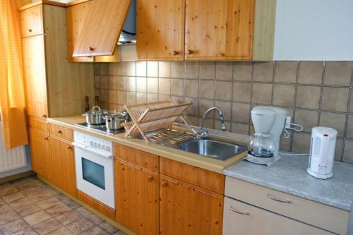 a kitchen with a sink and a stove top oven at Rote Koje in Dagebüll