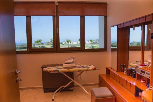 a room with windows and a table with a hat on it at VILLA ANTONIS in Kos