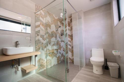 a bathroom with a toilet and a sink and a shower at Waiting Homestay in Taitung City