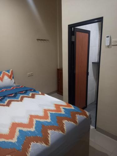 a bedroom with a bed with a colorful blanket at Barada Poris 