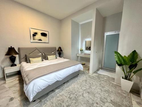Tanjong Sepat的住宿－The P Lakehouse，一间卧室配有一张大床和盆栽植物