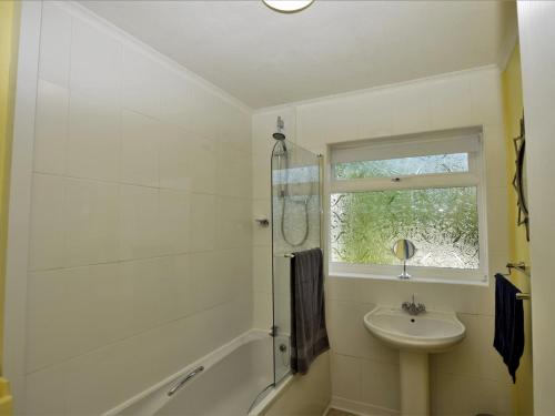 a white bathroom with a sink and a shower at 3 Bed in Great Snoring KT075 in Great Snoring