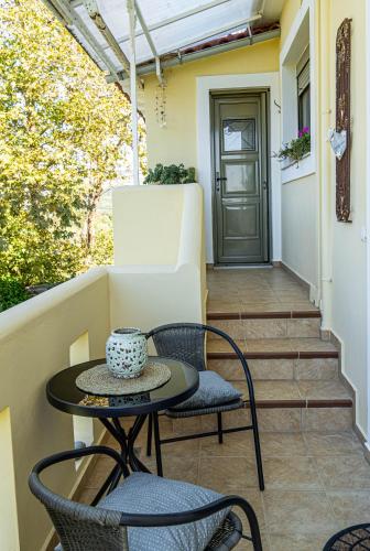 a patio with a table and chairs and a door at Estia guest house in Olympia