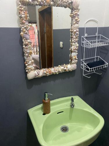 een badkamer met een wastafel met een spiegel en een spiegel bij Bintang Guesthouse in Gili Trawangan