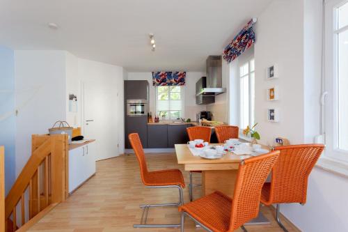 uma cozinha e sala de jantar com uma mesa de madeira e cadeiras em Ahlbecker Höhe App Strandkorb em Ahlbeck