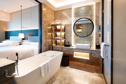 Baño del hotel con bañera y lavabo en Yantai Marriott Hotel, en Yantai