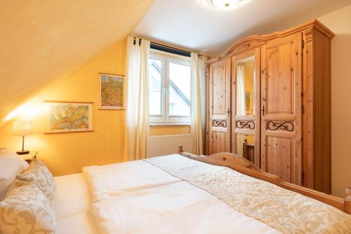1 dormitorio con 1 cama y un gran armario de madera en Strandläufer App 1, en Ahlbeck