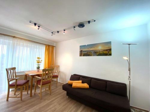 sala de estar con sofá y mesa de comedor en Süderhaus Hiddensee App 4 en Neuendorf