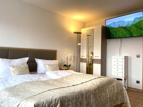 a bedroom with a large bed with a flat screen tv on the wall at Süderhaus Hiddensee App 8 in Neuendorf