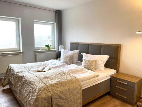 Un dormitorio con una cama con un libro. en Süderhaus Hiddensee App 8 en Neuendorf