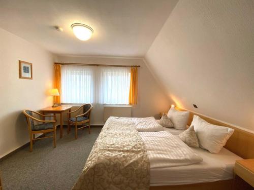 a hotel room with a bed and a table at Süderhaus Hiddensee App 9 in Neuendorf