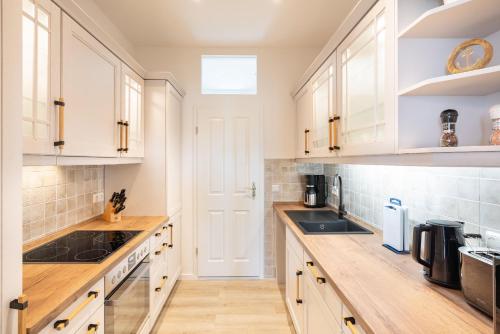 a kitchen with white cabinets and wooden counter tops at Villa Albus App 4 in Ahlbeck
