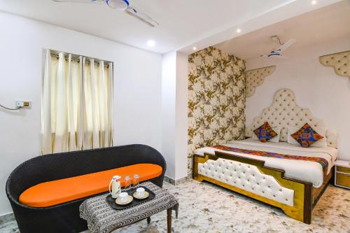 a bedroom with a bed and a chair and a table at FabHotel Prime Rockstar in Ballygunge
