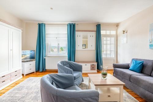 uma sala de estar com cortinas azuis e um sofá em Villa Albus App 8 em Ahlbeck