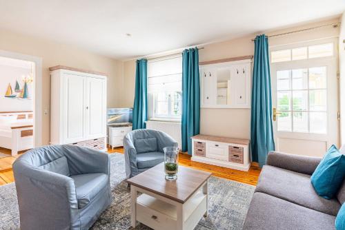 uma sala de estar com duas cadeiras e uma mesa em Villa Albus App 8 em Ahlbeck