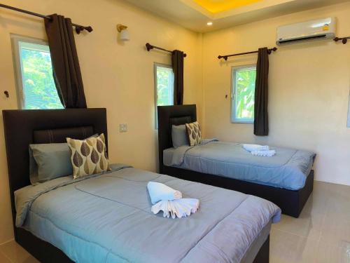 - 2 lits dans une chambre avec 2 fenêtres dans l'établissement Sunrise Beach Kohyao Resort, à Ko Yao Yai