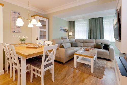 uma cozinha e sala de estar com uma mesa e um sofá em Villa Waldschloss App 2 em Bansin