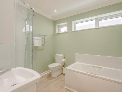 La salle de bains blanche est pourvue d'une baignoire et de toilettes. dans l'établissement 2 Bed in Bournemouth 78541, à Ferndown