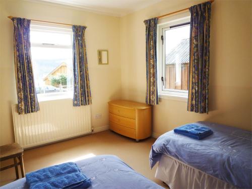 Tomdoun的住宿－3 Bed in Invergarry CA195，一间卧室设有两张床和两个窗户。
