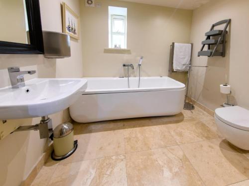 ein Badezimmer mit einer Badewanne, einem Waschbecken und einem WC in der Unterkunft 2 Bed in Harrogate 65305 in Harrogate