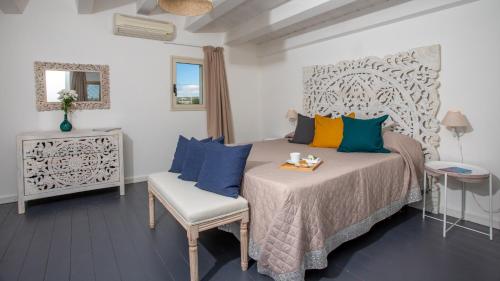 a bedroom with a bed with blue and yellow pillows at PROFUMO DI ZAGARA 6&2 Emma Villas in Ispica