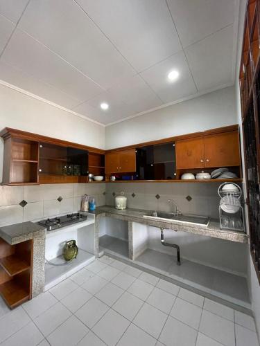 Una cocina con gabinetes de madera y encimera. en Villa Walikota, en Bogor
