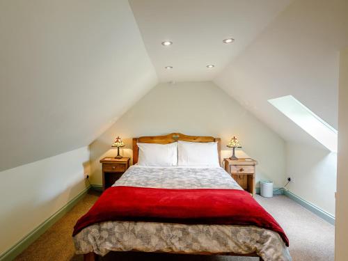 Schlafzimmer im Dachgeschoss mit einem Bett mit einer roten Decke in der Unterkunft 1 bed property in Tansley 61938 in Tansley