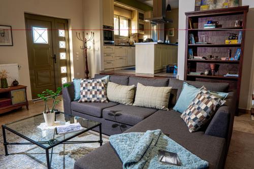 a living room with a couch and a kitchen at Estia guest house in Olympia