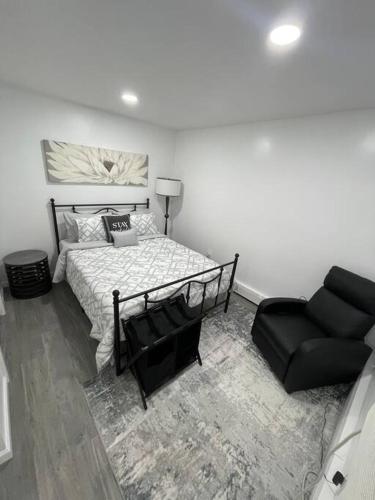 - une chambre avec un lit et une chaise noire dans l'établissement Modern/new 1br Apt- Shops 5mn, à Massapequa