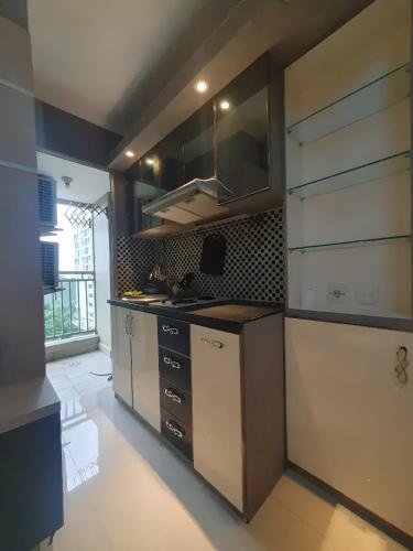 cocina con fogones y armarios en una habitación en Apartemen Gading Icon, en Yakarta