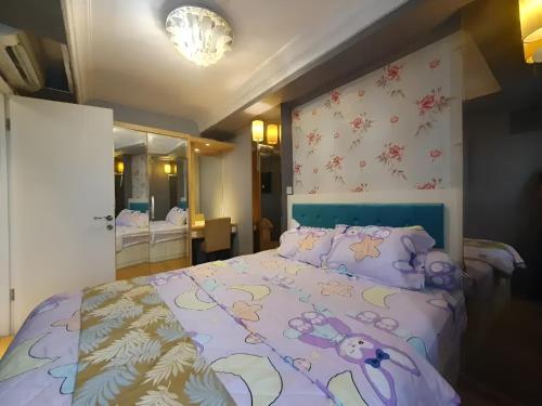 1 dormitorio con 1 cama con edredón morado en Apartemen Gading Icon, en Yakarta