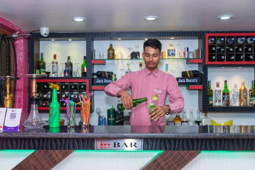 a man standing at a bar preparing a drink at HOTEL ROYAL INN,NUWAKOT. in Trisūli Bāzār