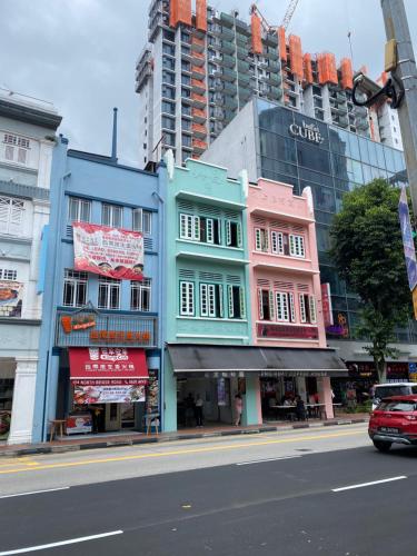 a group of colorful buildings on a city street at Backpacker Cozy Corner Guesthouse in Singapore