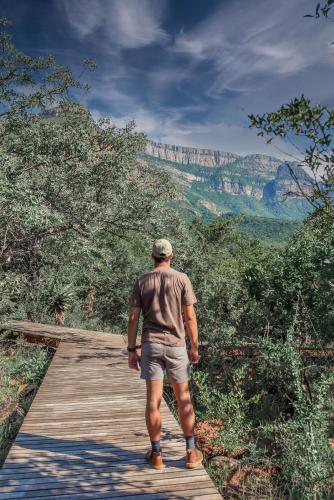 a man walking on a wooden path in the grand canyon at umVangati House in Hoedspruit