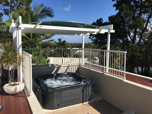 uma banheira de hidromassagem numa varanda com um gazebo em Oasis Rooftop Spa Apartment em Noosa Heads