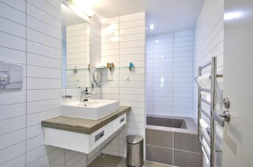 a white bathroom with a sink and a shower at Pure Retreat Lake Views in Queenstown