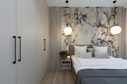 a bedroom with a large bed and a wall with plants at Elite Apartments Sienna Grobla Prestige in Gdańsk