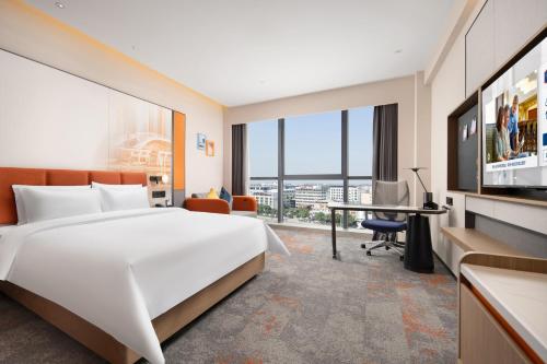 a hotel room with a large bed and a desk at Hampton by Hilton Guangzhou Renhe Baiyun Airport-Free shuttle bus for canton fair in Guangzhou