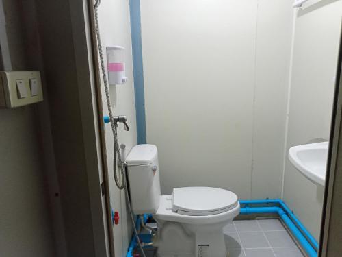 a bathroom with a toilet and a sink at ปวินท์เกสต์เฮาส์ in Ban Pong Khlum