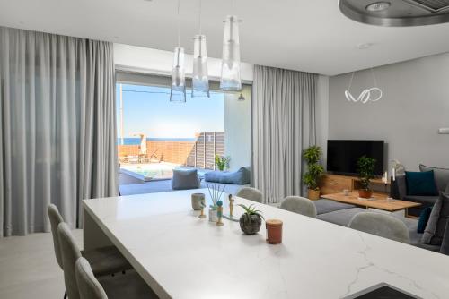 una sala de estar con una gran mesa blanca y sillas en Anasa Luxury Villas with Heatable Pool, en Kokkíni Khánion