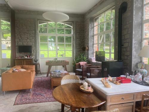 a living room with a table and chairs and windows at LE CHATEAU DE MONTHUREUX LE SEC in Monthureux-le-Sec