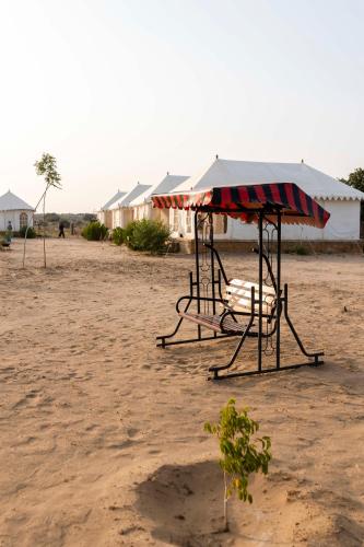 a swing set with a canopy on a beach at Nomads heaven desert camp jaisalmer in Jaisalmer