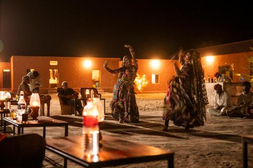 two women dancing on a stage at night at Nomads heaven desert camp jaisalmer in Jaisalmer