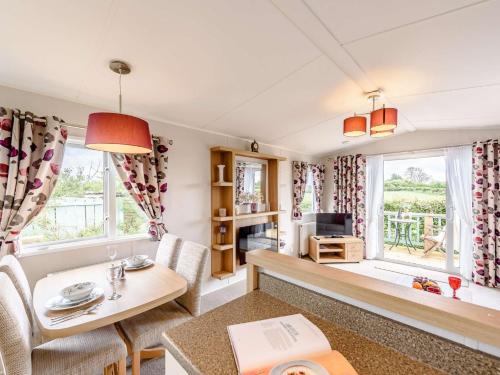 2 Bed in Newborough 82559 في Brynsiencyn: غرفة معيشة مع طاولة وكراسي ونافذة