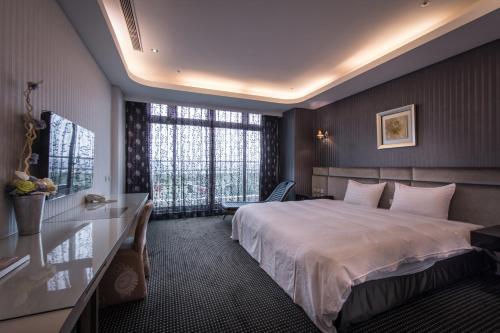 una camera d'albergo con letto e finestra di Shianghu Boutique Hotel a Città di Chiayi