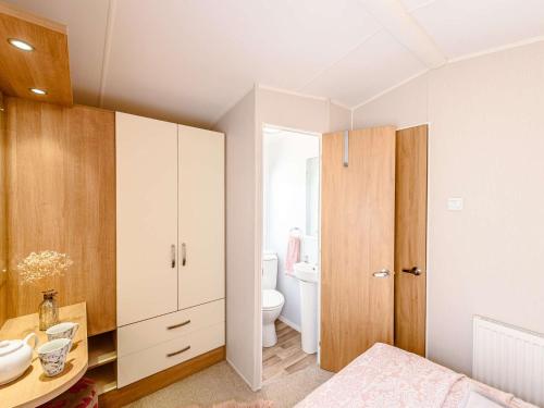 2 Bed in Newborough 82559 في Brynsiencyn: حمام مع حوض ومرحاض في الغرفة